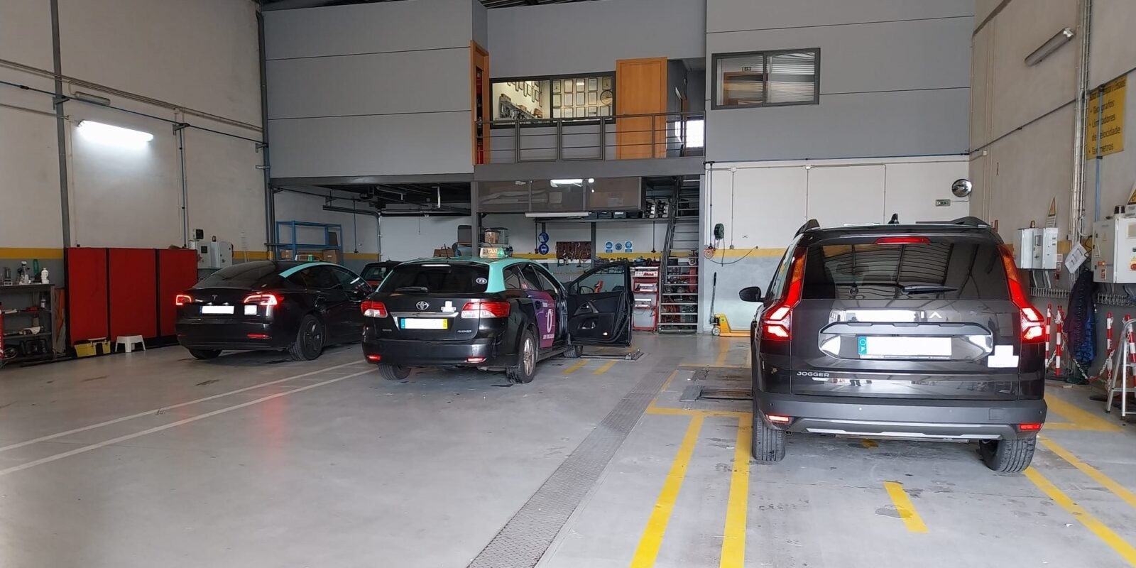 Interior da oficina STEMA com viaturas em zonas de trabalho